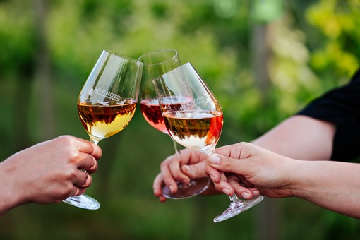 image of three wine glasses clinking together.