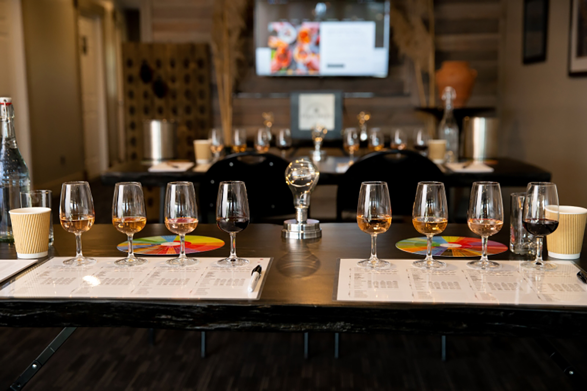 Image of tables set with rows of wine bottles for wine class.