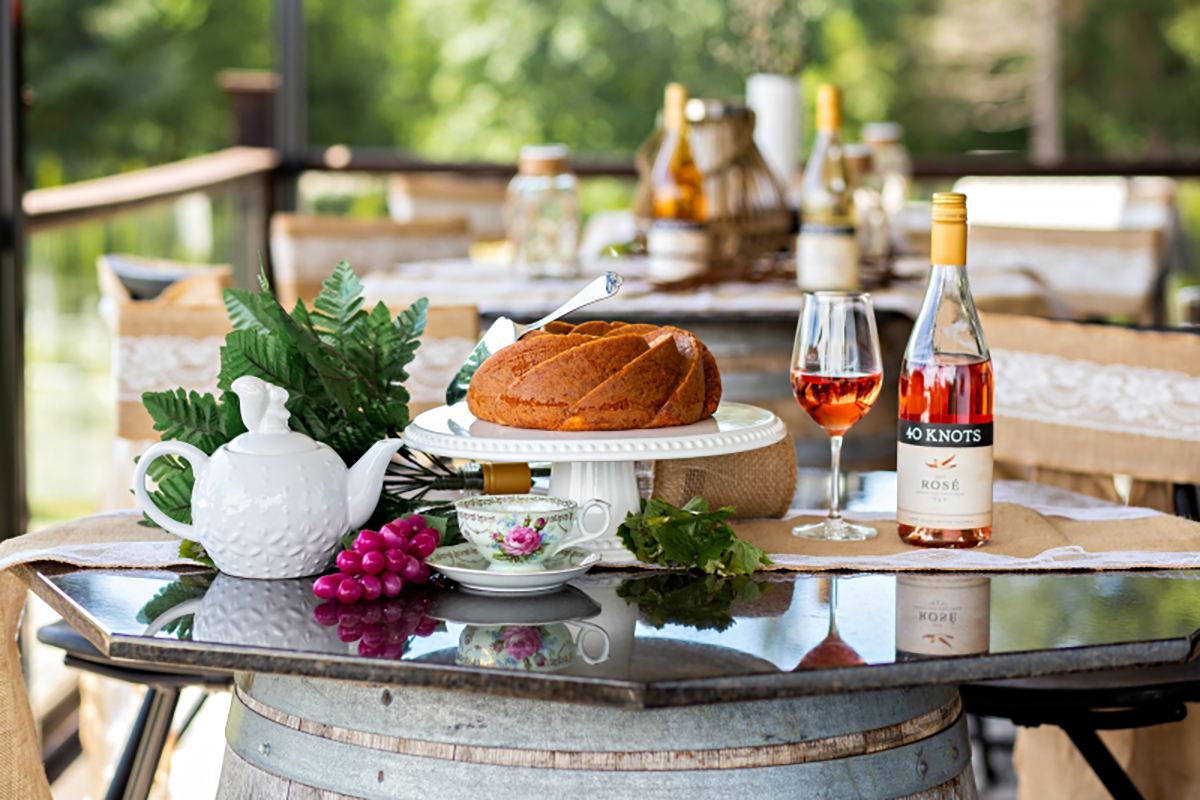 Image of table setting with tea set and wine and cheeses.