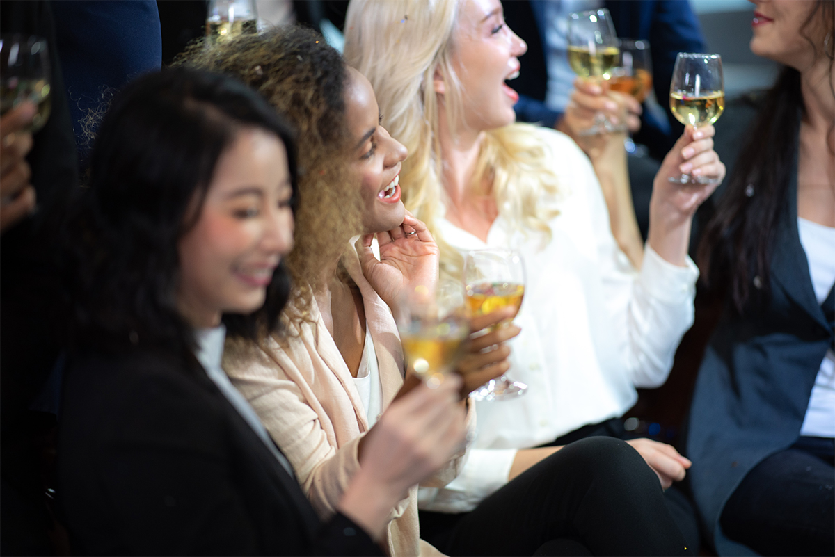 Image of business women at event drinking wine.