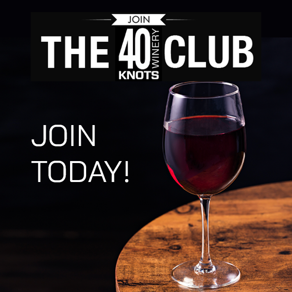 Image with 40 Knots Wine Club logo above a glass of red wine sitting on a wooden wine barrel.