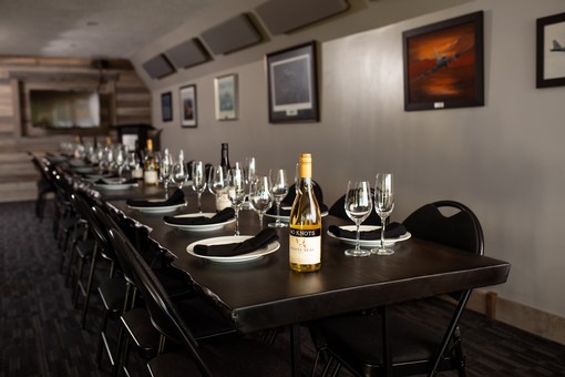 image of long boardroom table set with dinnerware and wine glasses