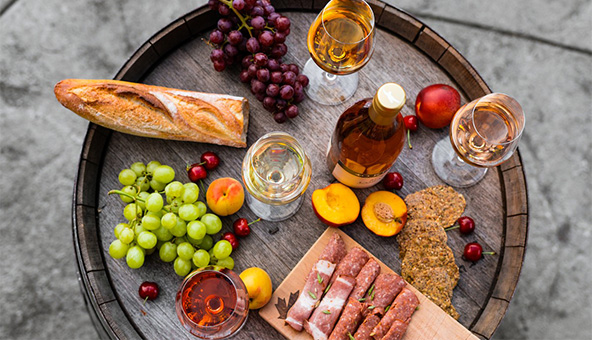 Picnic spread including baguette, fruit and wine