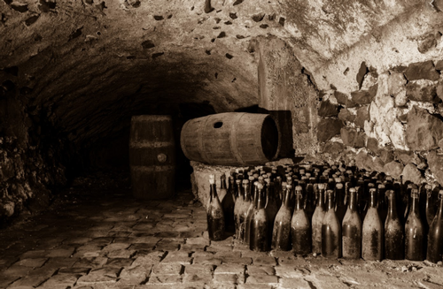 image of old wine bottles and casks in ancient cellar