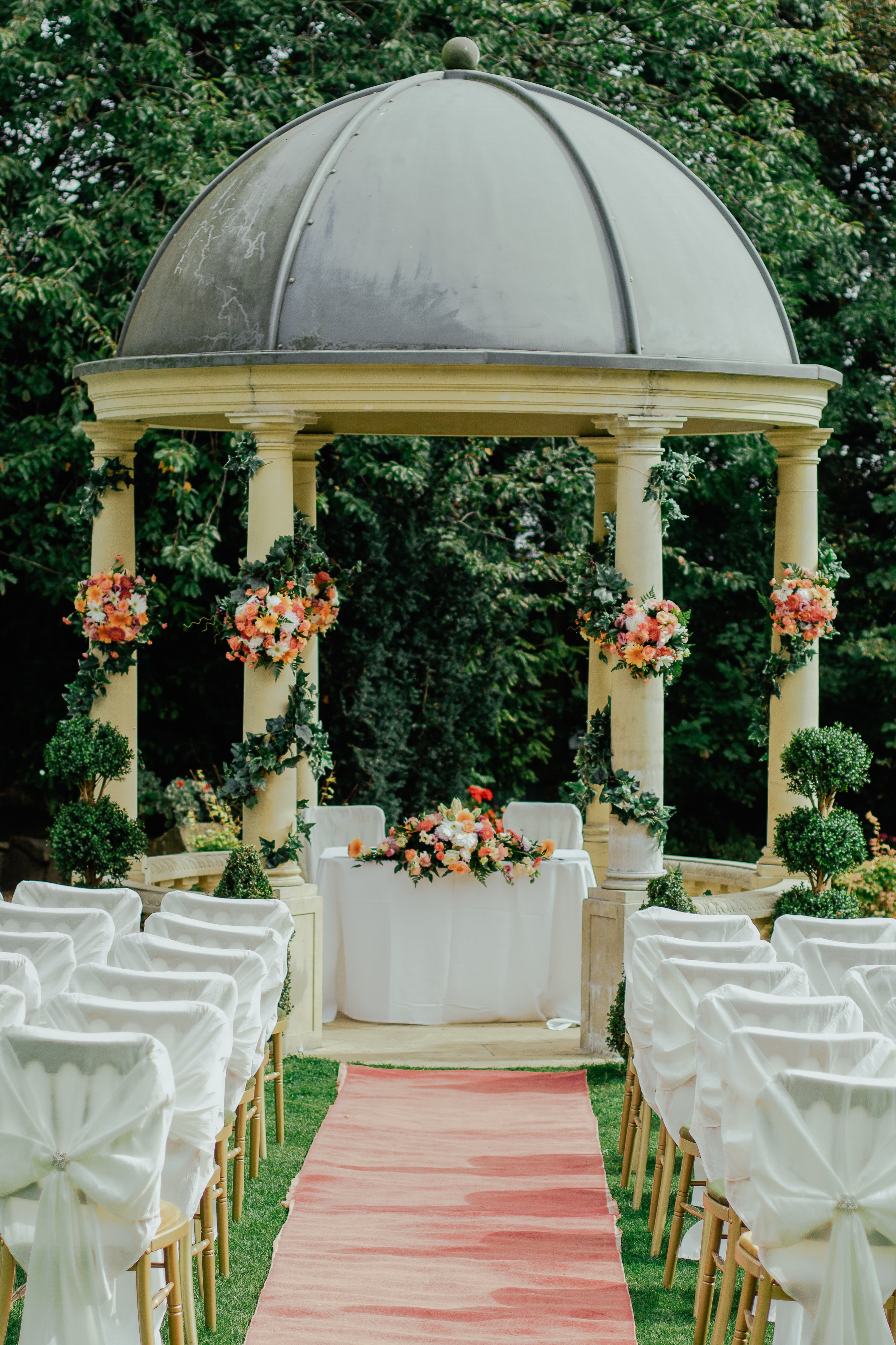 Image of wedding setup with chairs, flowers and alter